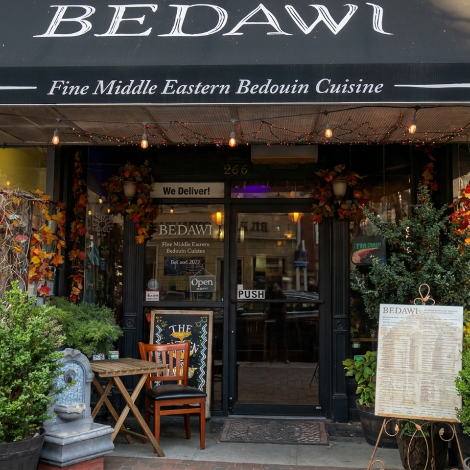 Bedawi restaurant storefront with Middle Eastern cuisine signage, autumn decorations, potted greenery, and an outdoor table and chair.
